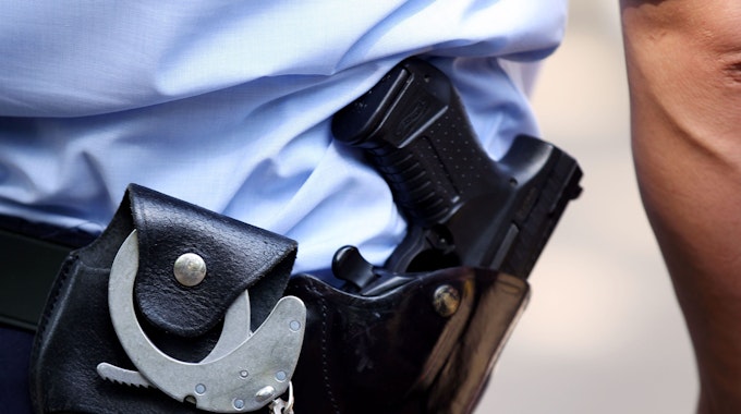 Ein Polizist mit Handschellen und Pistole am Gürtel.&nbsp;