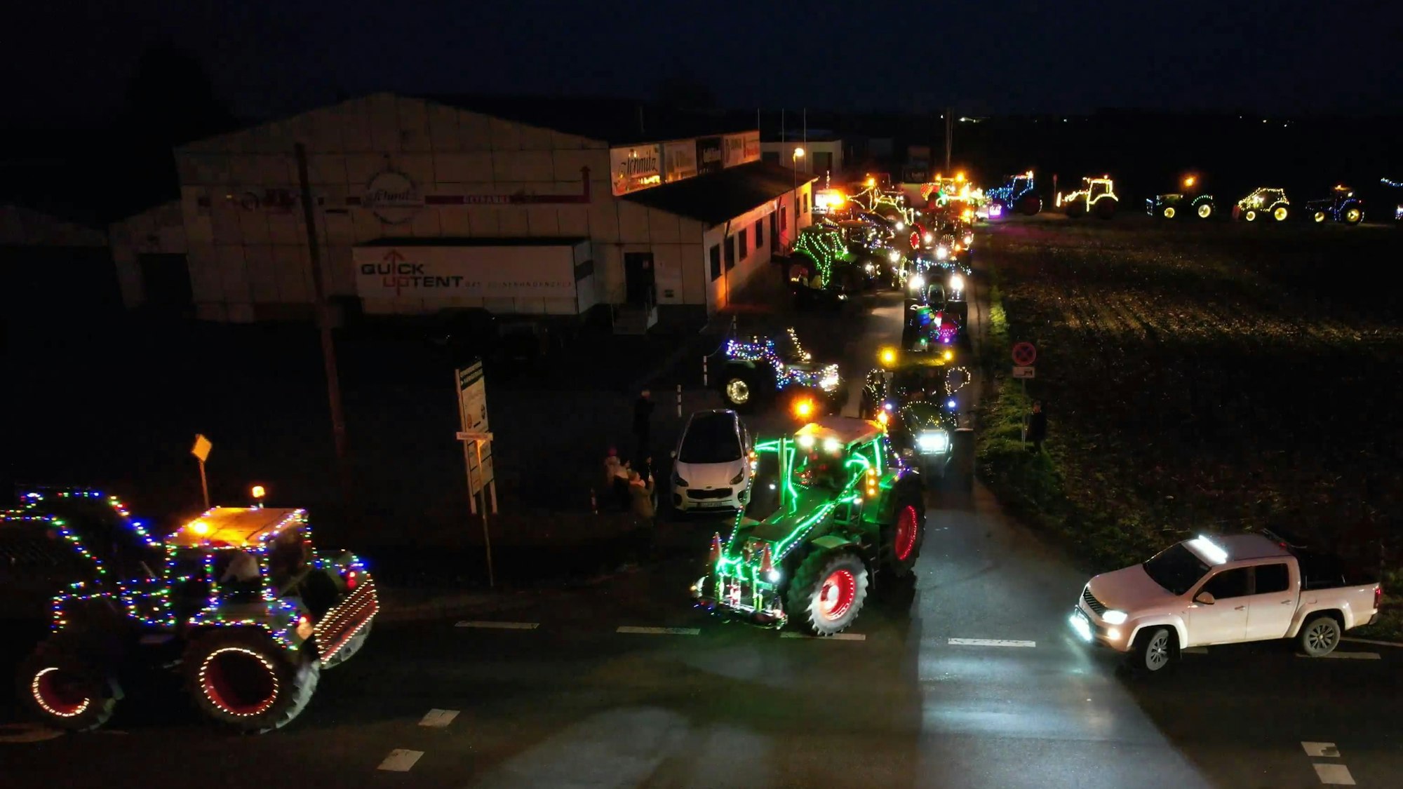 Mit Lichterketten geschmückte Traktoren fahren durch Wißkirchen.