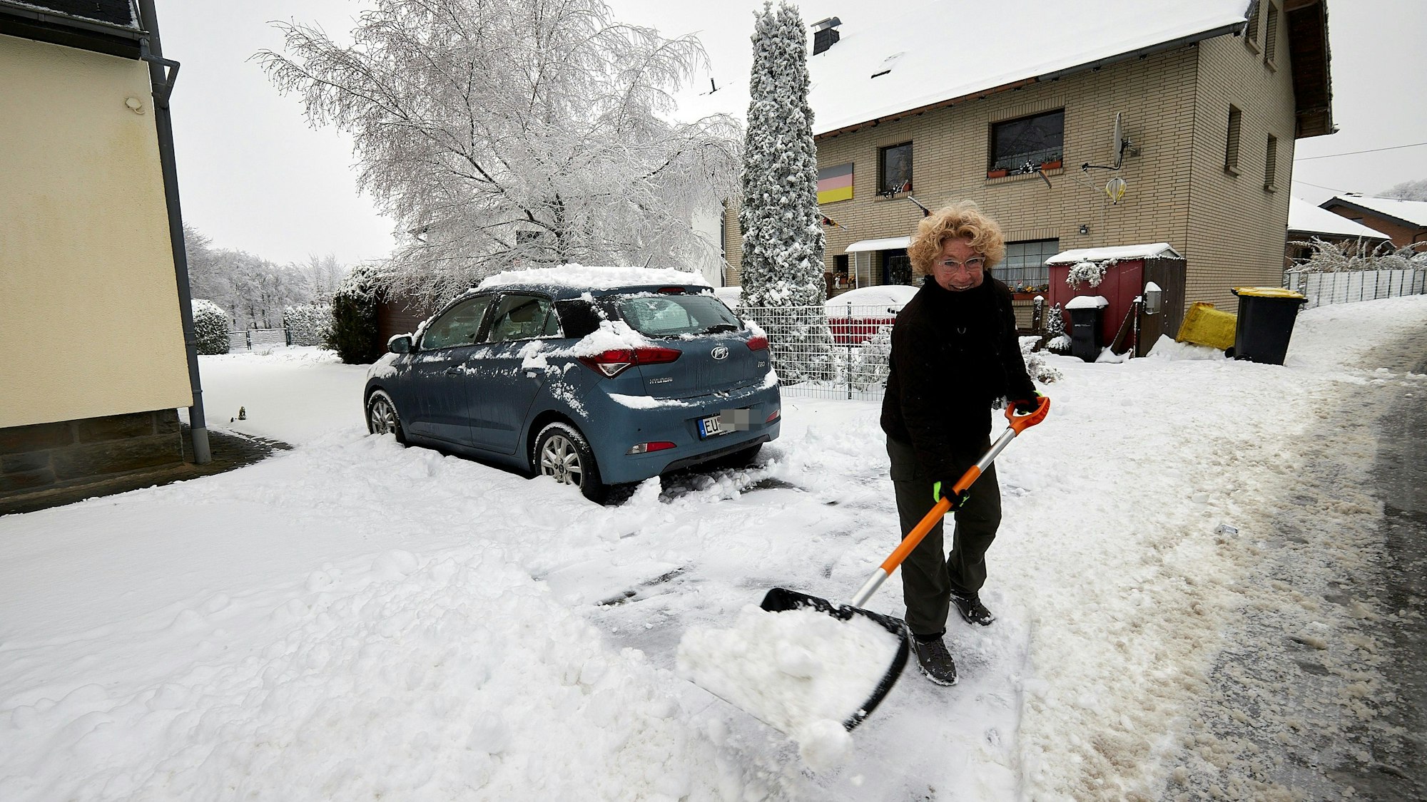Die Udenbretherin Doris Haep schaufelt ihre Hauseinfahrt frei, in der rund zehn Zentimeter Schnee liegt.