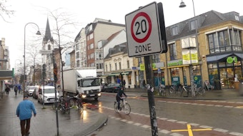 Ein Radfahrer fährt an einem Hinweisschilder auf Tempo 20 an einer Zufahrtsstraße der Venloer Straße vorbei.