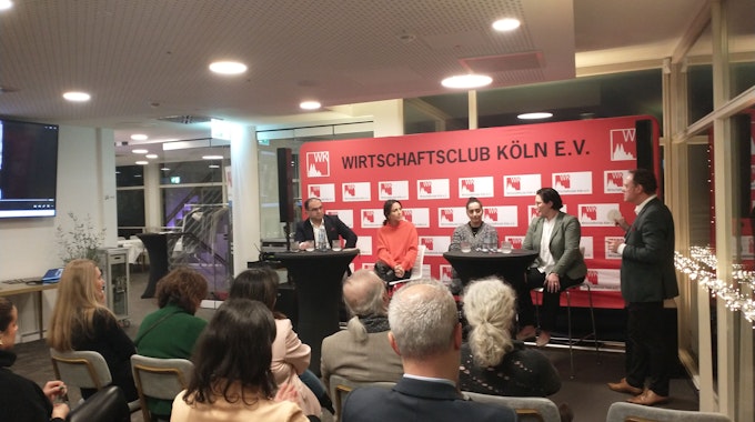 Kölner Wirtschaftsclub mit 4 Podiumsgästen und Moderator, im Vordergrund Publikum.