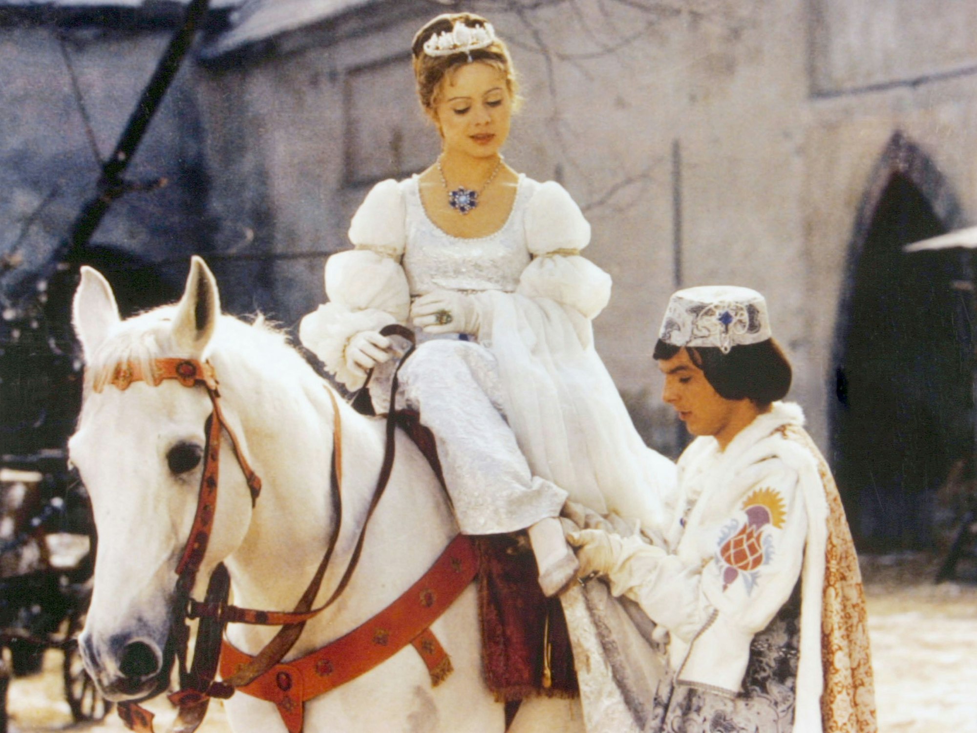 Der Prinz (Pavel Trávnícek) passt Aschenbrödel (Libuse Safránková) den verlorenen Schuh an in einer Szene aus „Drei Haselnüsse für Aschenbrödel“.
