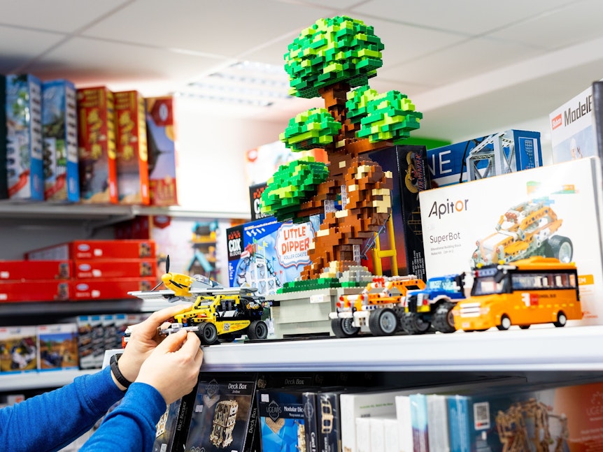 Das Bild zeigt ein Spielzeuggeschäft, in dem verschiedene Spielwaren ausgestellt sind.