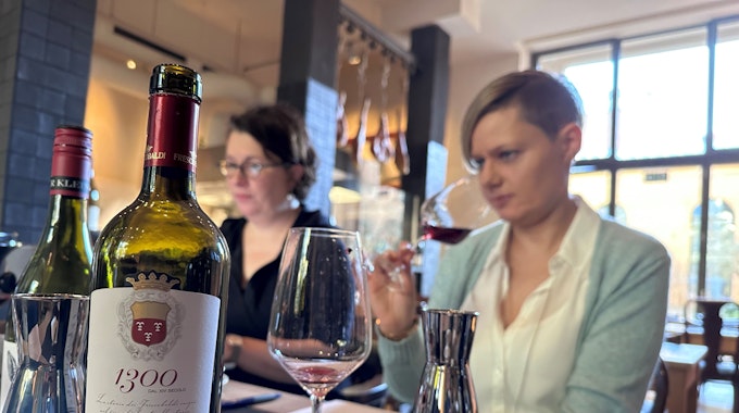 Romana Echensperger (l.) und Annette Schwarz sitzen am Tisch und testen Weine.