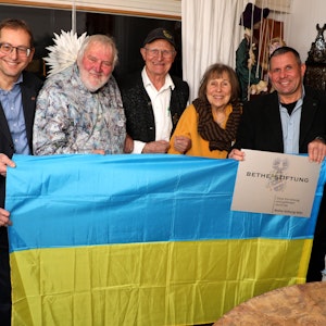 Beteiligte der Ukraine-Hilfe und der Bethe-Stiftung halten eine Ukraine-Flagge vor sich.