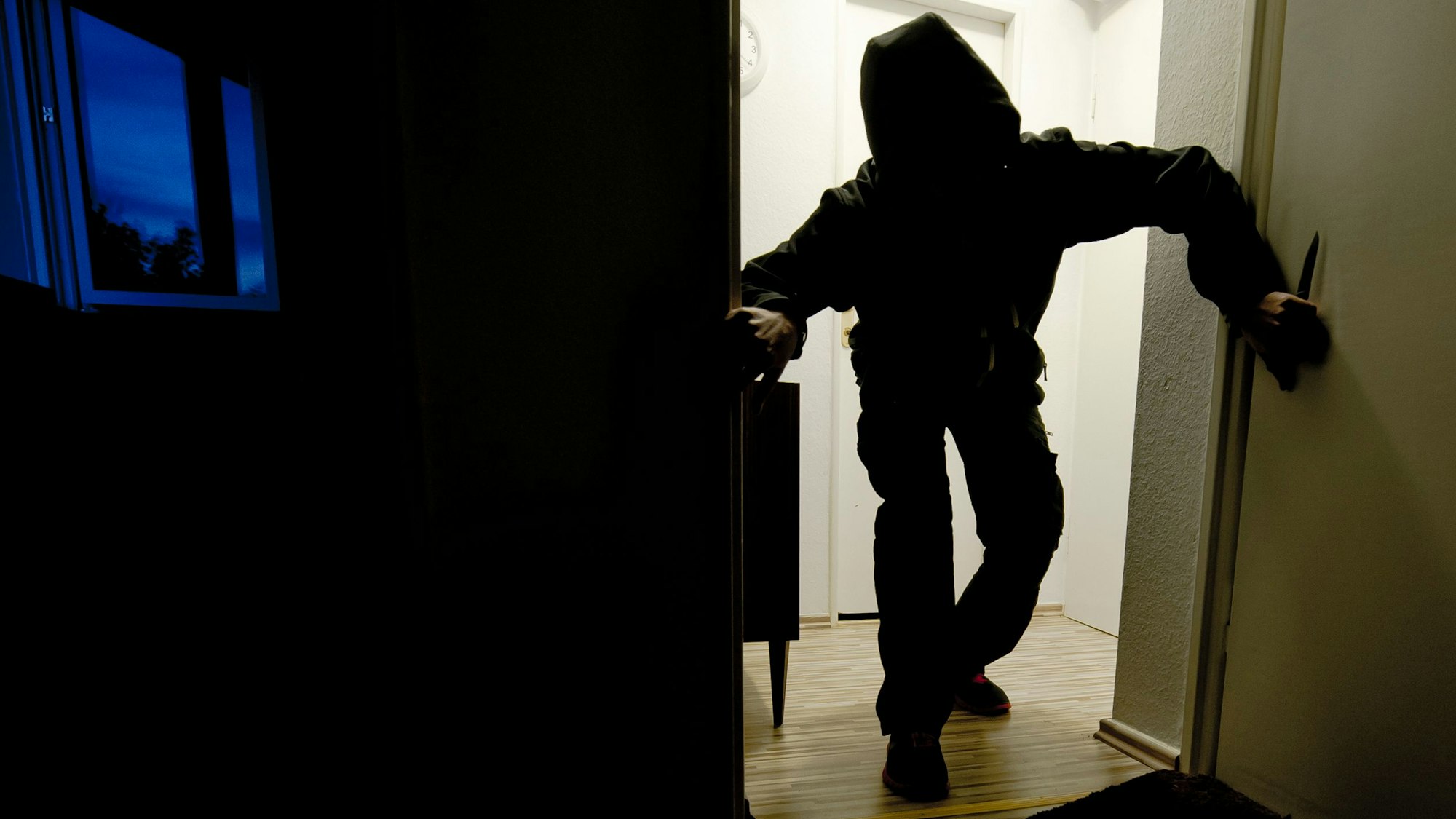 Ein Einbrecher schleicht durch eine dunkle Wohnung (Symbolfoto).