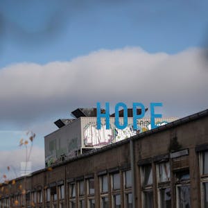 Der Schriftzug H O P E - das englische Wort für Hoffnung - installiert in blauen Versalien an einem Lüftungsschacht auf dem Dach der früheren KHD-Hallen auf dem Otto-Langen-Quartier im Mülheimer Süden.