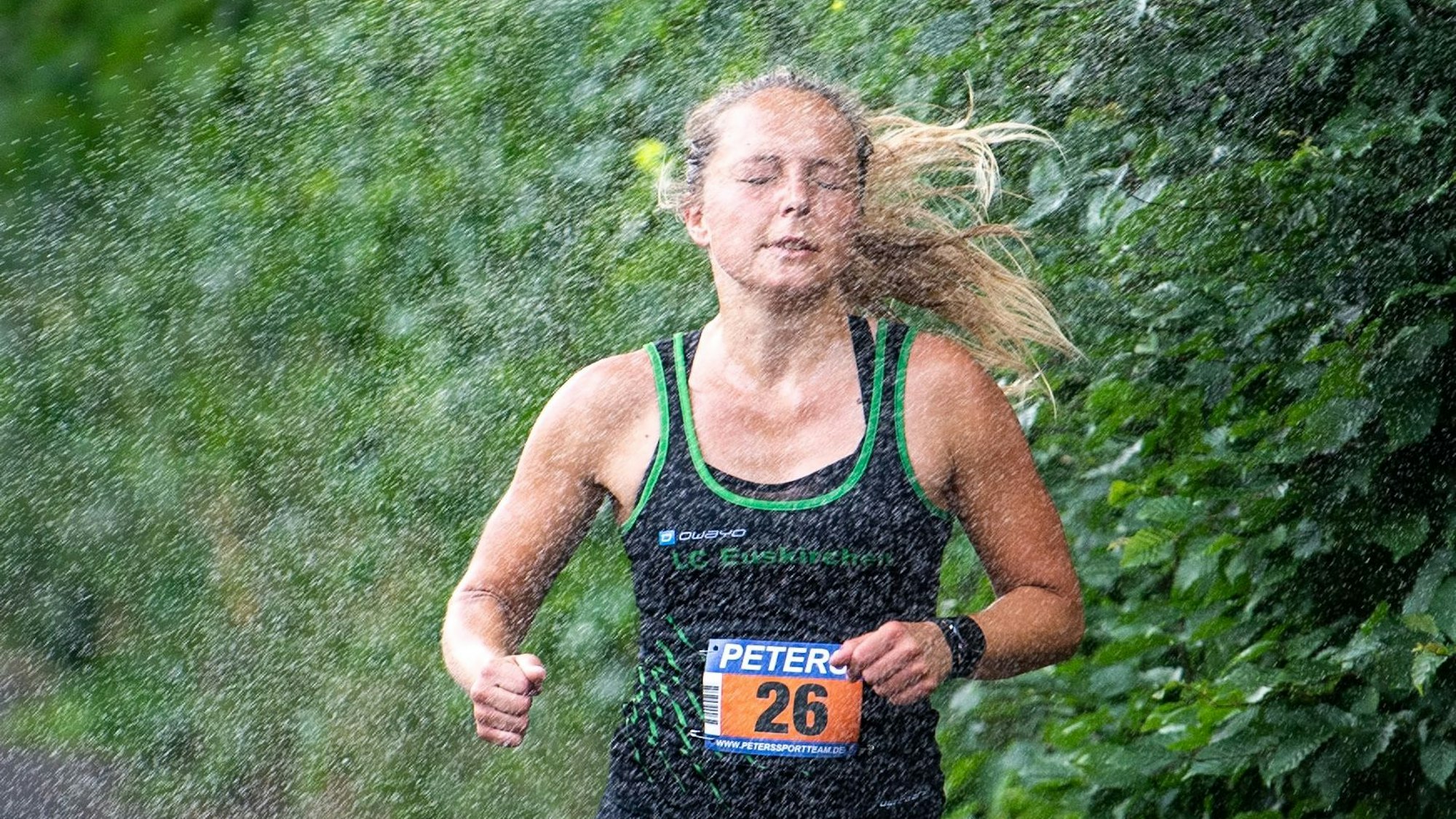 Beim Eifelcup-Lauf in Kreuzweingarten läuft die spätere Gesamtsiegerin Nora Schmitz durch den Strahl einer am Wegesrand abgestellten Dusche.