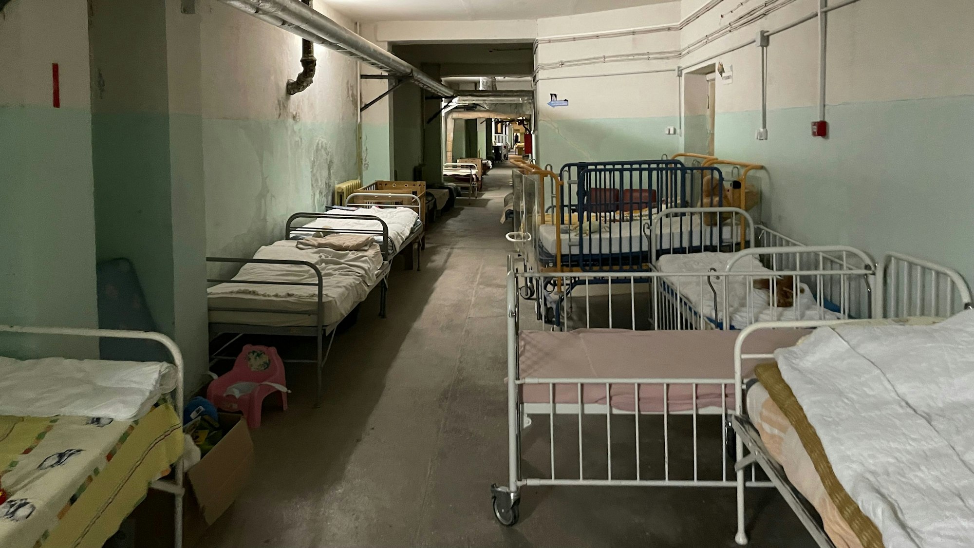 Ein Flur im Kinderkrankenhaus in Lviv mit Betten an den Wänden.
