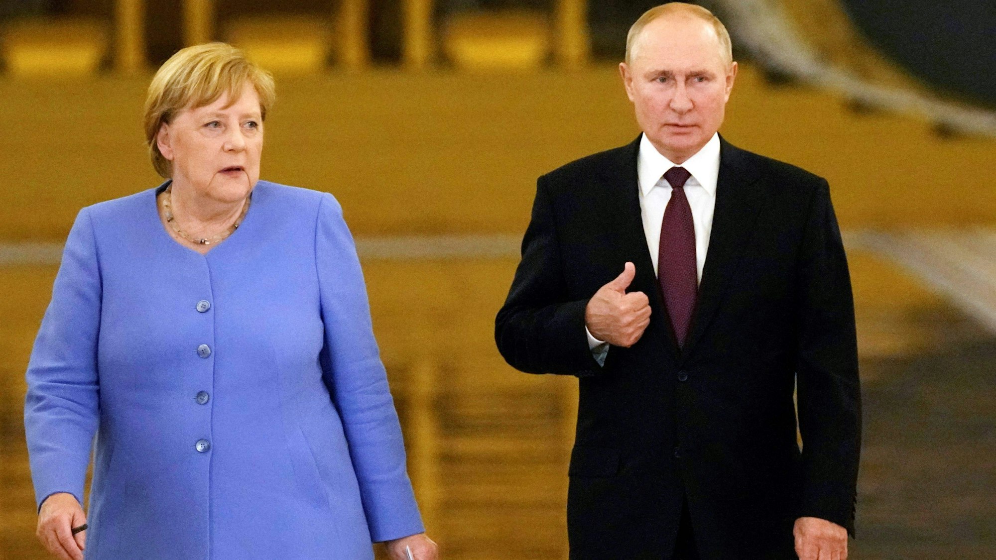 Altkanzlerin Angela Merkel (CDU) steht neben dem russischen Präsidenten Wladimir Putin, beide tragen formale Kleidung und blicken ernst.