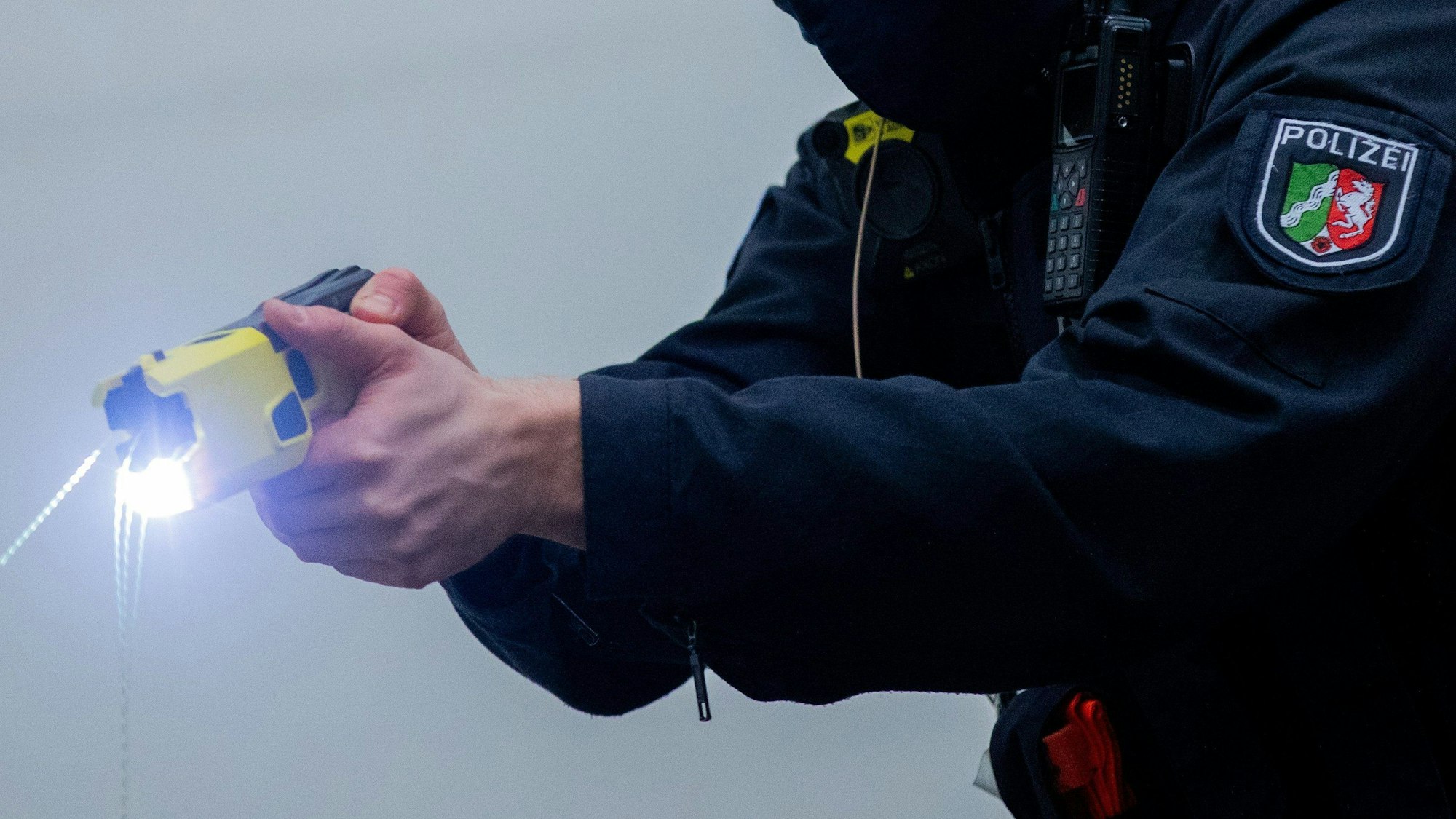 Ein Polizeibeamter demonstriert einen Schuss mit einem Distanz-Eelektroimpulsgerät (DEIG).