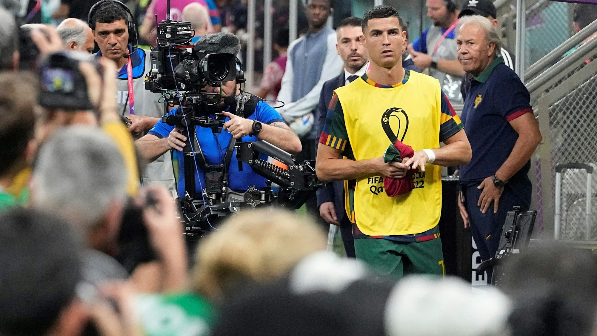 Cristiano Ronaldo marschiert vor dem WM-Achtelfinale zwischen Portugal und der Schweiz Richtung Ersatzbank. Dort erwartet ihn bereits eine Meute von Fotografinnen und Fotografen.