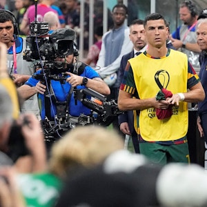 Cristiano Ronaldo marschiert vor dem WM-Achtelfinale zwischen Portugal und der Schweiz Richtung Ersatzbank. Dort erwartet ihn bereits eine Meute von Fotografinnen und Fotografen.