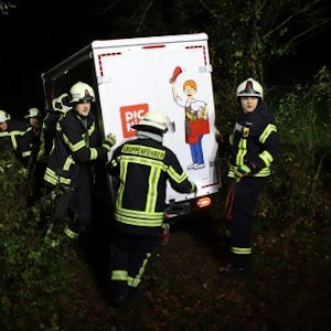 Feuerwehrleute stützen einen Van des Lieferdienstes Picnic in einer steilen Böschung.