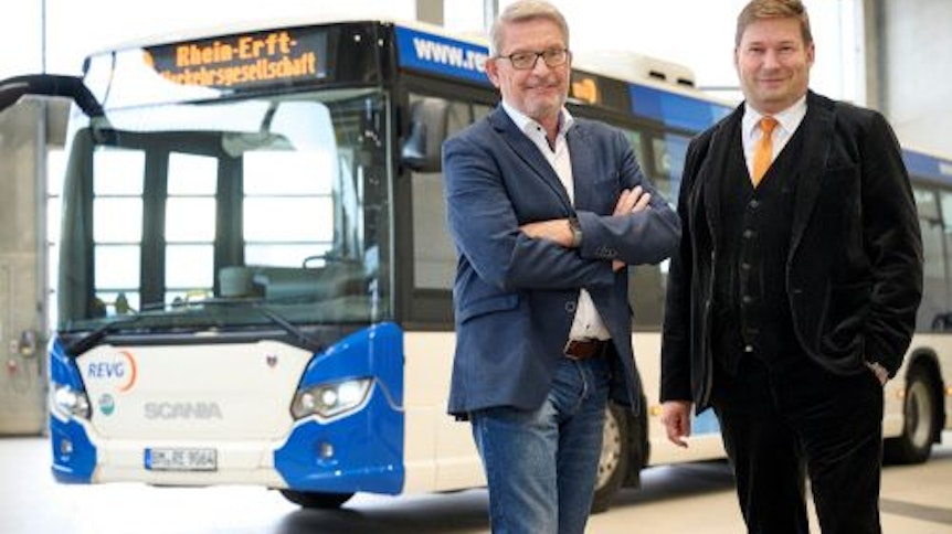 Die REVG-Geschäftsführer Walter Reinarz und Martin Gawrisch stehen vor einem Linienbus.