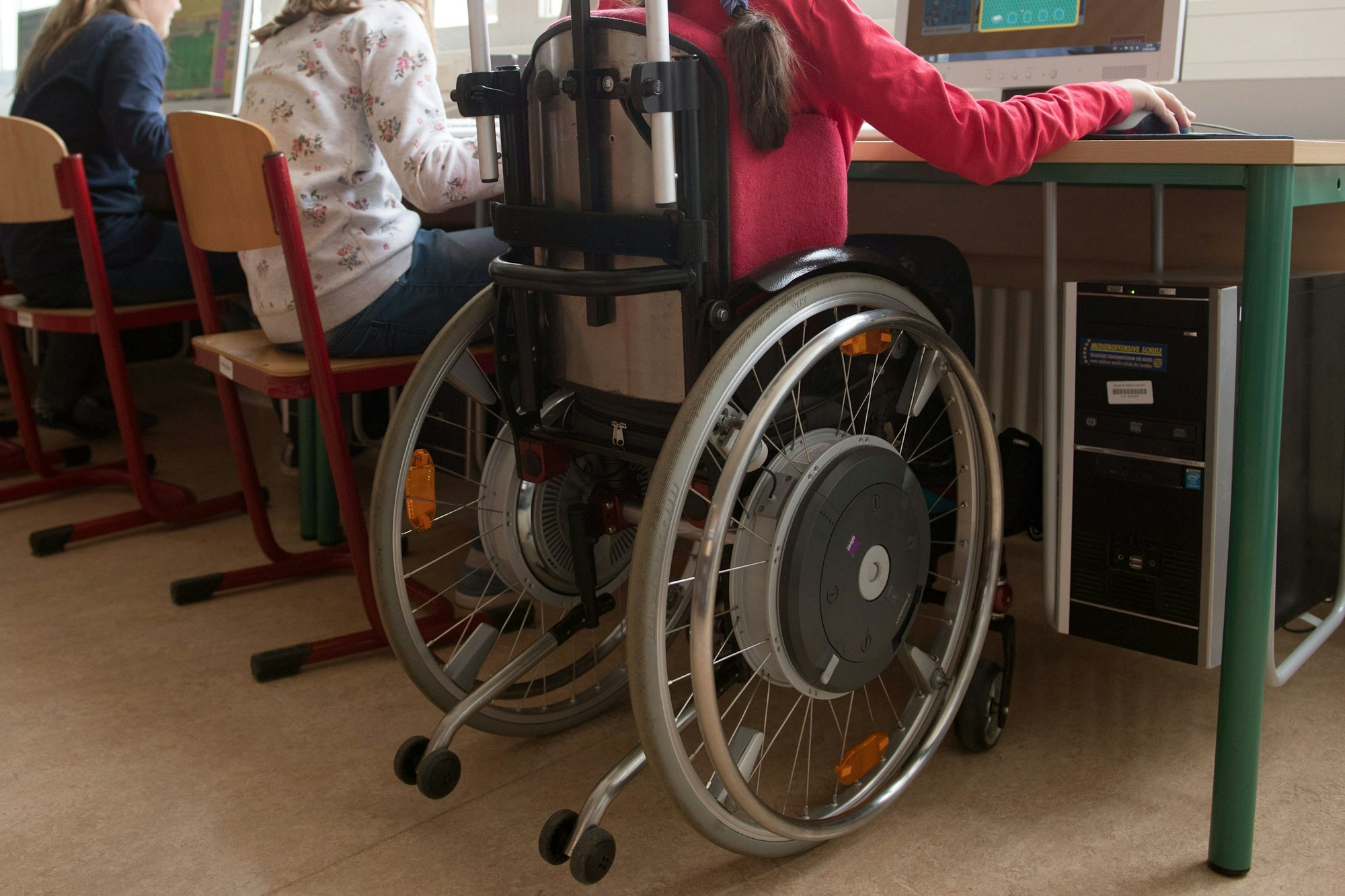 Eine Schülerin sitzt in einem Rollstuhl im Computerraum.