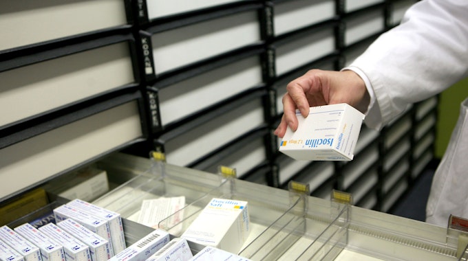 &nbsp;Eine Apothekerin nimmt in einer Apotheke in Köln ein Medikament aus dem Schrank.