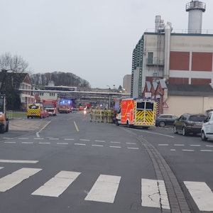 Feuerwehrwagen und Rettungswagen stehen vor einer Produktionshalle des Siegwerks.