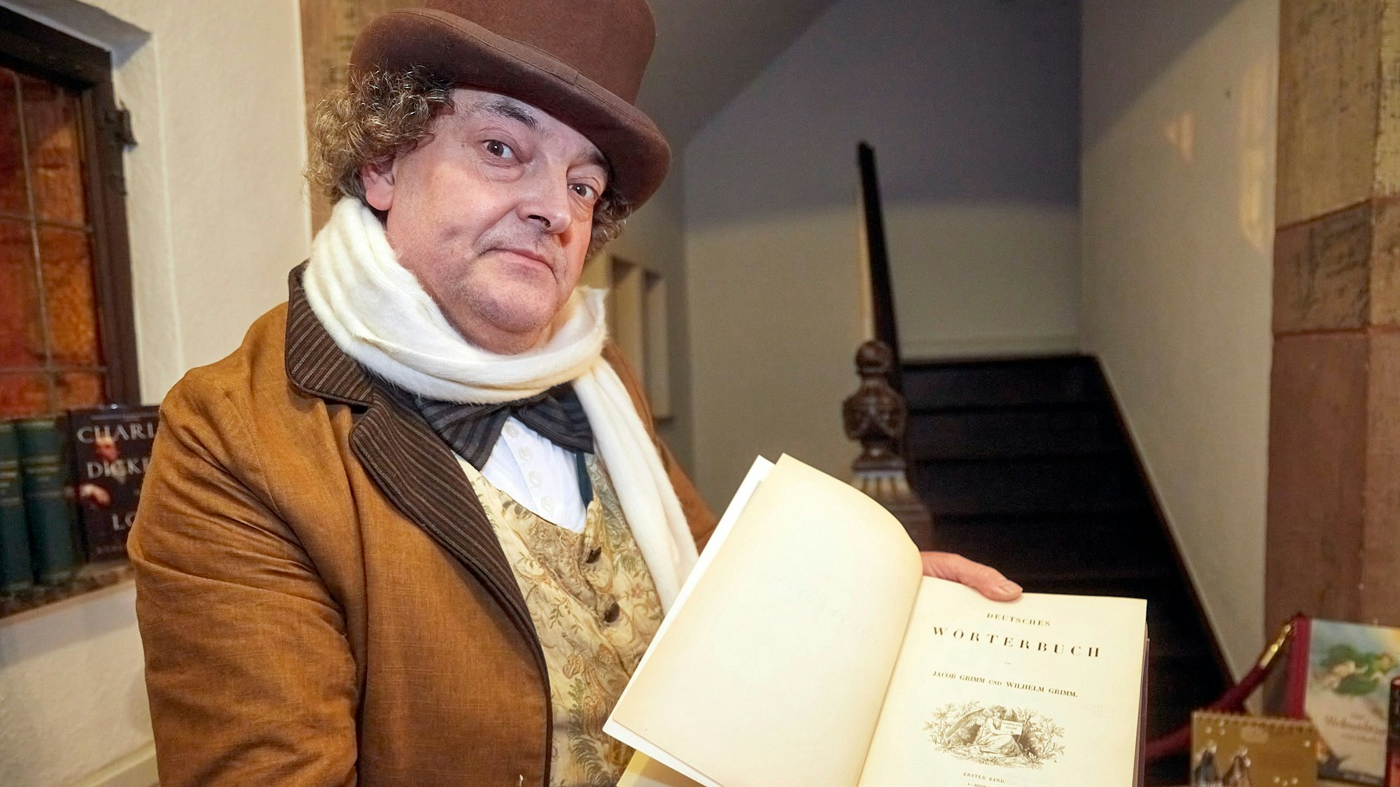 Der Geschichtenerzähler „Jacob Grimm“ präsentiert im Trauzimmer der Burg ein Exemplar des ersten deutschen Wöterbuchs.