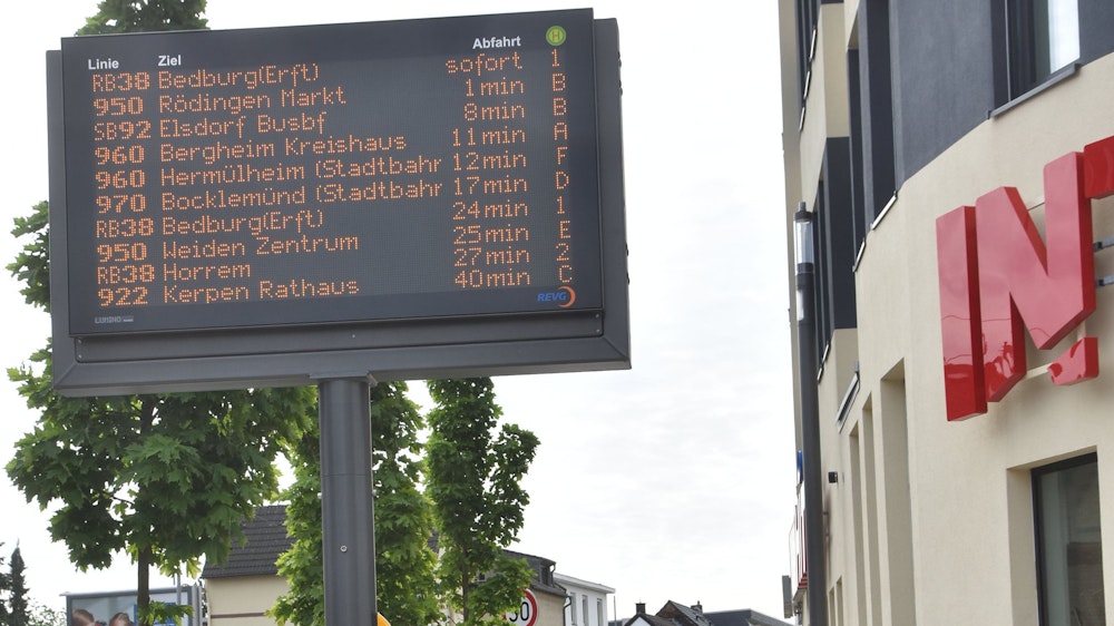 Auf einer elektronischen Tafel ist an einer Haltestelle in Bergheim zu sehen, wann die nächsten Busse kommen.