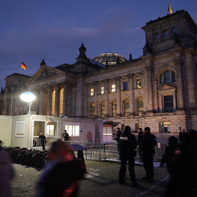 Besucher und Polizisten stehen vor dem Reichstag in Berlin.