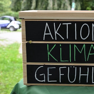 Ein Holzkasten mit der Aufschrift auf schwarzem Grund: „Aktion, Klima, Gefühle“