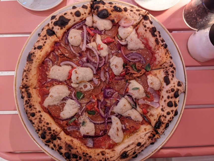 Eine Pizza mit Salami, Peperonis und Zwiebeln.