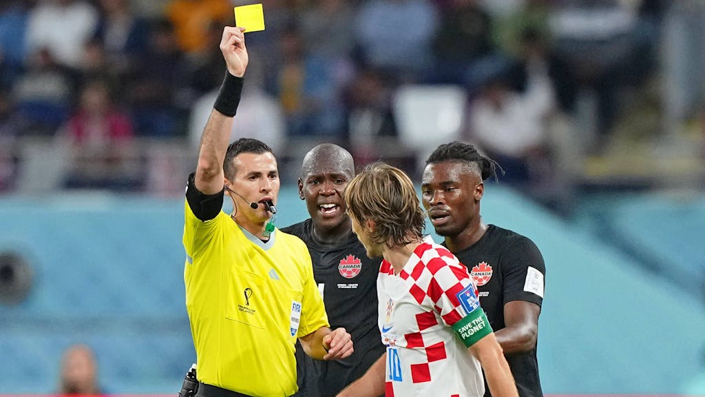 Schiedsrichter Andres Matonte zeigt Luka Modric und Kamal Miller im WM-Gruppenspiel zwischen Kroatien und Kanada am 27. November 2022 die Gelbe Karte.