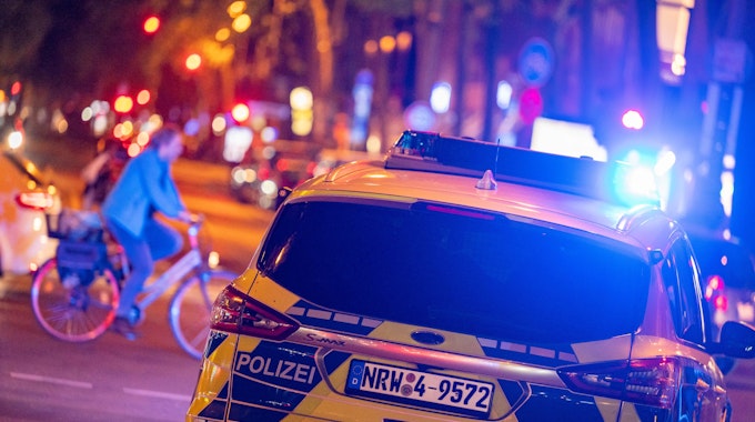 Ein Polizeiauto fährt auf einer Straße bei Nacht.