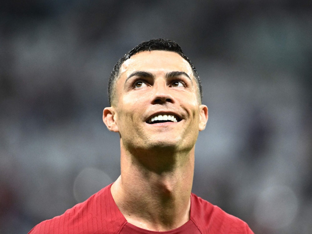 Cristiano Ronaldo schaut lachend nach oben.