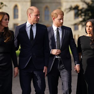 Kate, Prinzessin von Wales, William, Prinz von Wales, Prinz Harry, Herzog von Sussex, und seine Frau Meghan, Herzogin von Sussex, laufen vor dem Schloss Windsor einen Weg entlang.