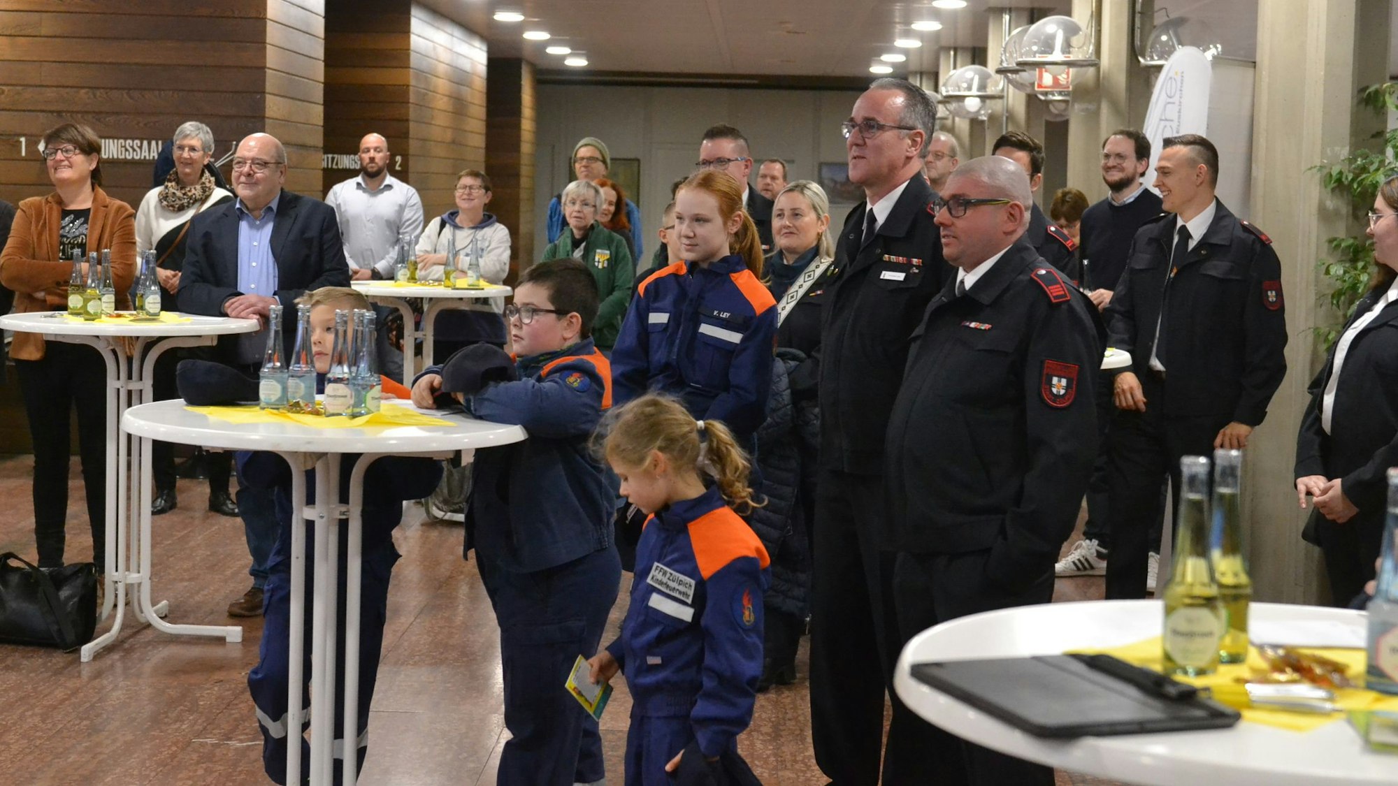 Im Euskirchener Kreishaus verfolgen zahlreiche Ehrenamtler, darunter eine Reihe von Feuerwehrleuten und Mitglieder der Jugendwehren, die Ausstellungseröffnung.
