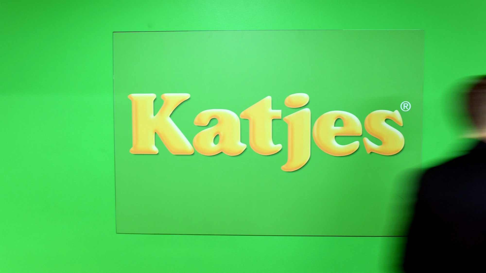 Das grün-gelbe Logo des Süßwarenherstellers Katjes in einer Produktionshalle des Unternehmens.