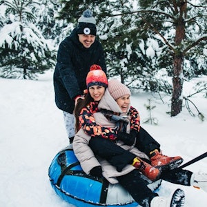 Friends ride tubing in the snow in winter