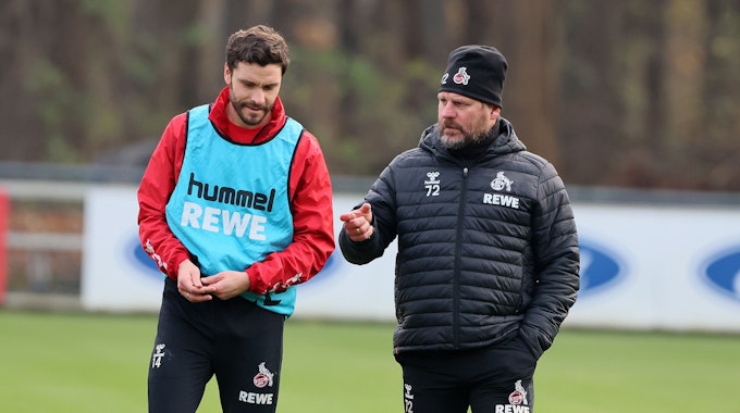 Jonas Hector und Steffen Baumgart sprechen beim Training des 1. FC Köln.