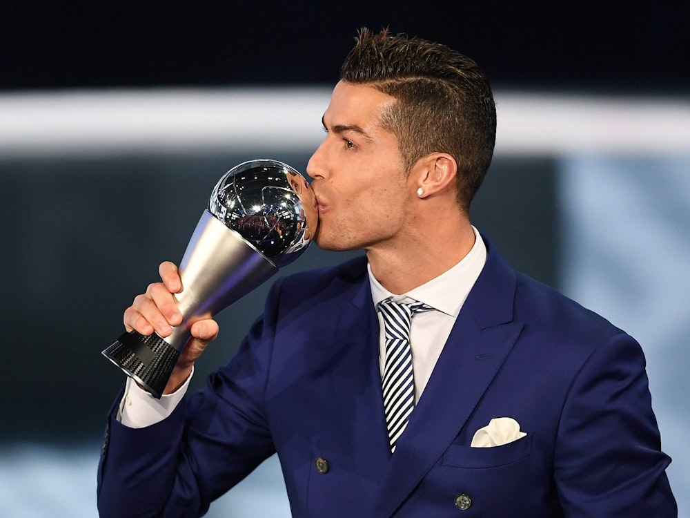 Cristiano Ronaldo küsst den Weltfußballer-Pokal.