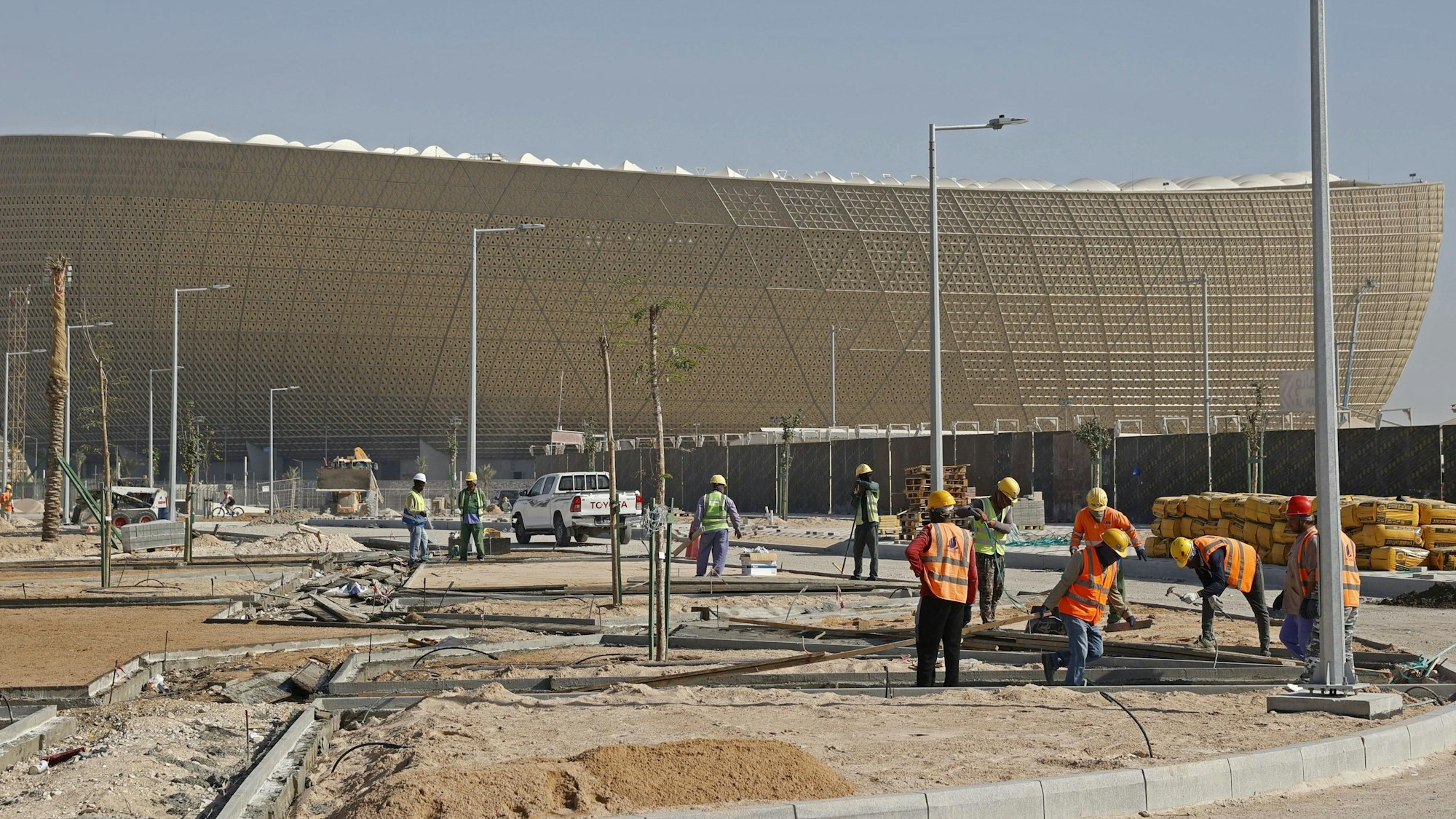 Bauarbeiter arbeiten vor dem Lusail Iconic Stadium, der Final-Arena bei der WM 2022.