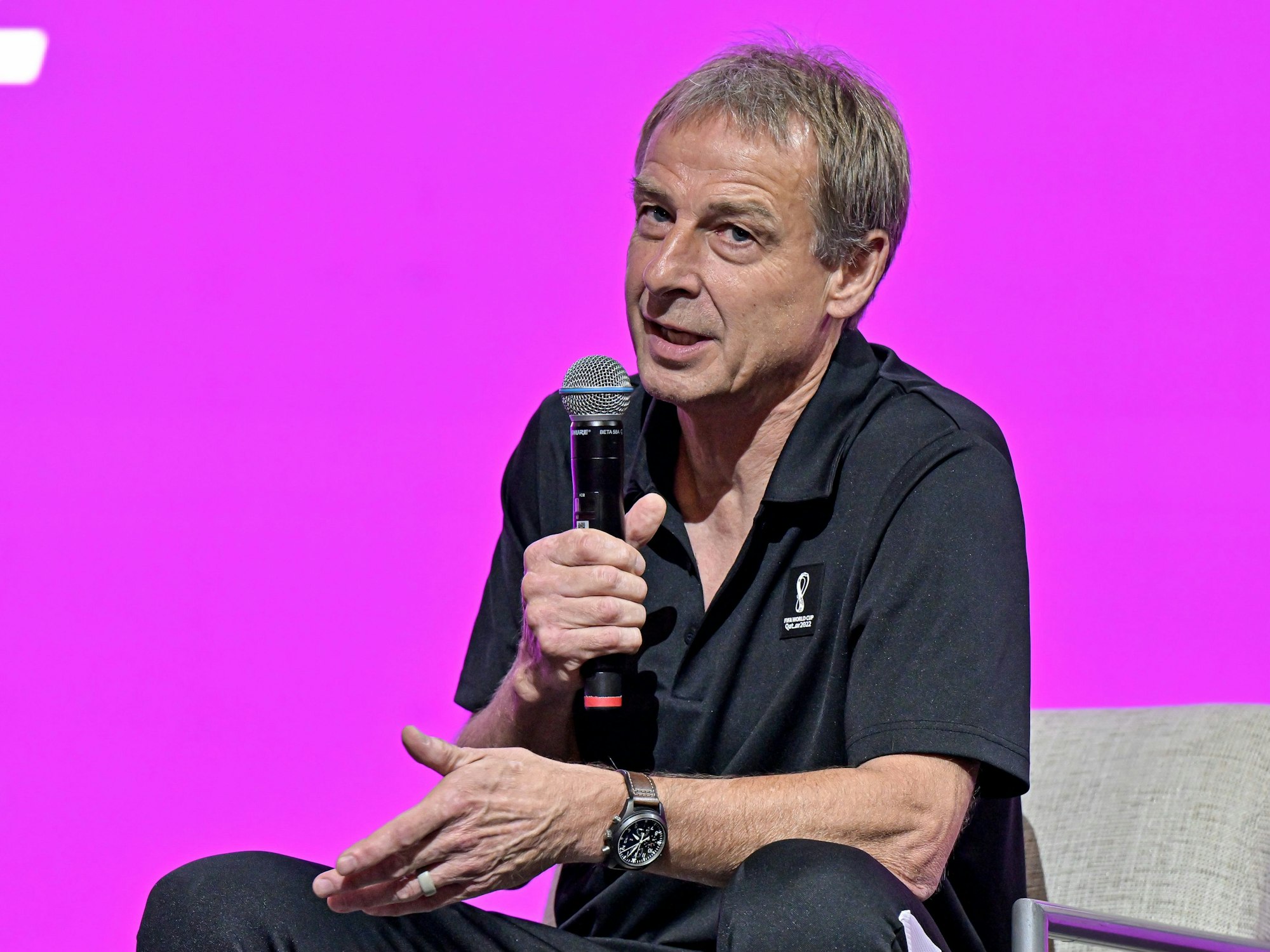 Jürgen Klinsmann spricht auf einer Bühne in Katar in ein Mikrofon.
