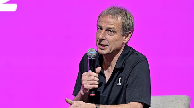 Jürgen Klinsmann spricht auf einer Bühne in Katar in ein Mikrofon.