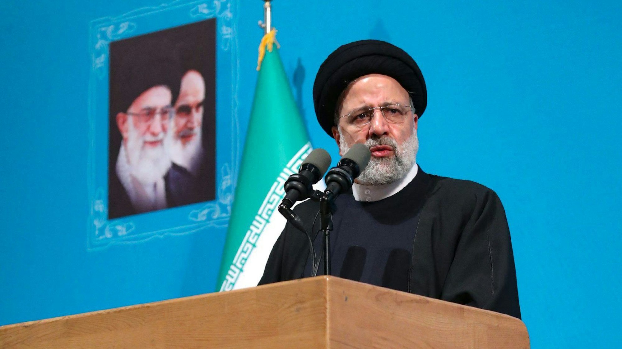 Irans Präsident Ebrahim Raisi steht an einem Rednerpult.