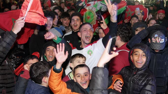 Das Bild zeigt zahlreiche Marokkaner auf der Straße in Bergheim, die den Sieg ihrer Mannschaft friedlich feiern.