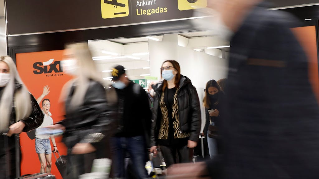 Touristinnen und Touristen kommen am Flughafen von Palma de Mallorca an.
