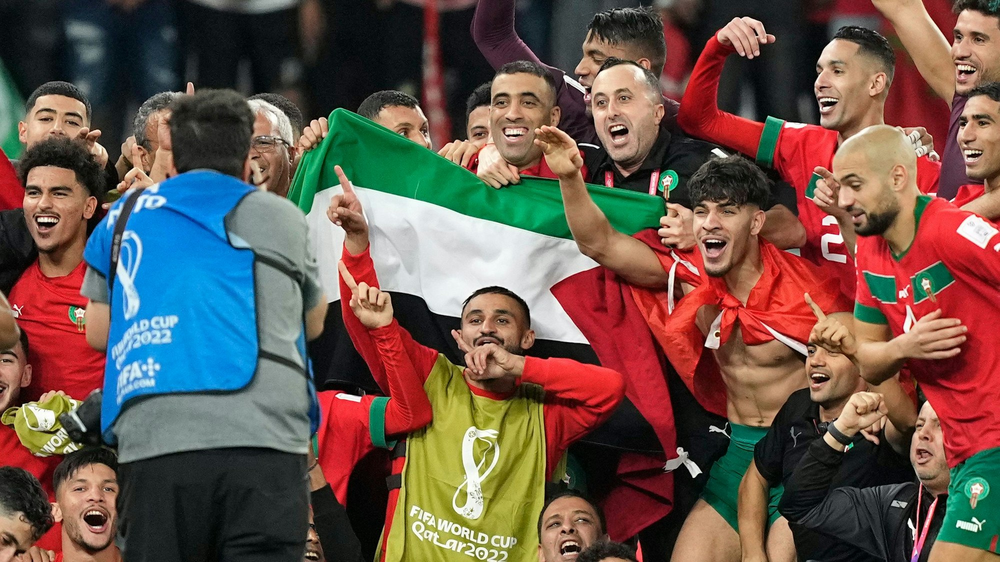 Marokkos Mannschaft posiert nach dem Sieg über Portugal für ein Gruppenfoto auf dem Spielfeld mit einer palästinensischen Flagge.