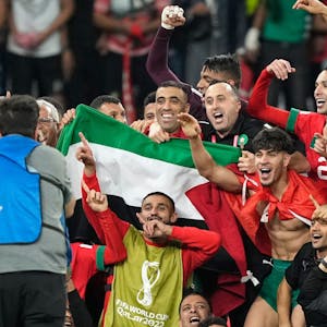 Marokkos Mannschaft posiert nach dem Sieg über Portugal für ein Gruppenfoto auf dem Spielfeld mit einer palästinensischen Flagge.