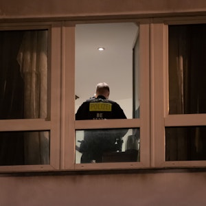Ein Polizist steht in einem Zimmer eines Hotels und durchsucht es.