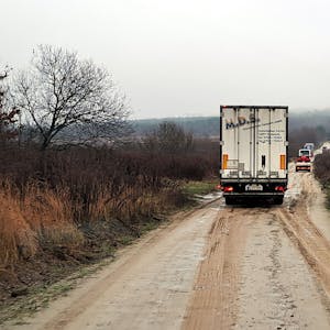 Ein Lkw fährt auf einem braunen Weg in der ukrainischen Landschaft.
