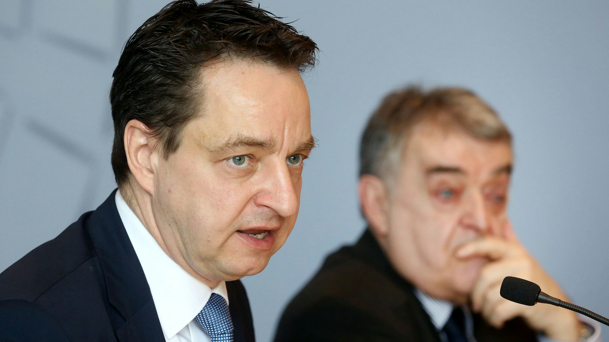 Der neue Verfassungsschutz-Chef Jürgen Kayser (l) sitzt bei einer Pressekonferenz neben NRW-Innenminister Herbert Reul (CDU) und spricht in ein Mikrofon.