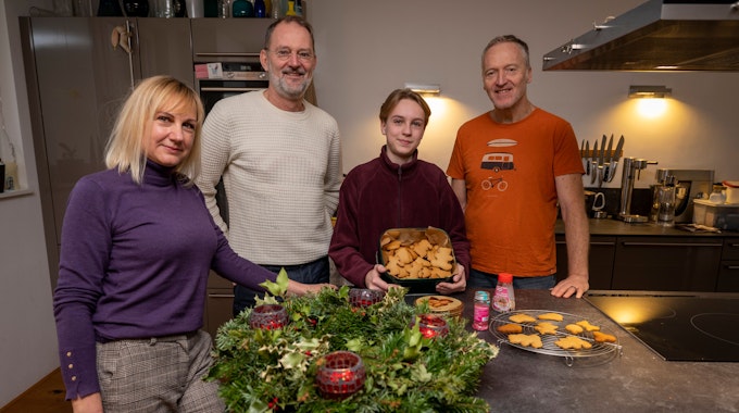 Svetlana Kiktieva und ihr Sohn Oleksij stehen zusammen mit ihren Gastgebern&nbsp;Michael Znamencek und Gert van der Kwartel vor einem Adventskranz und Plätzchen in der Küche.&nbsp;