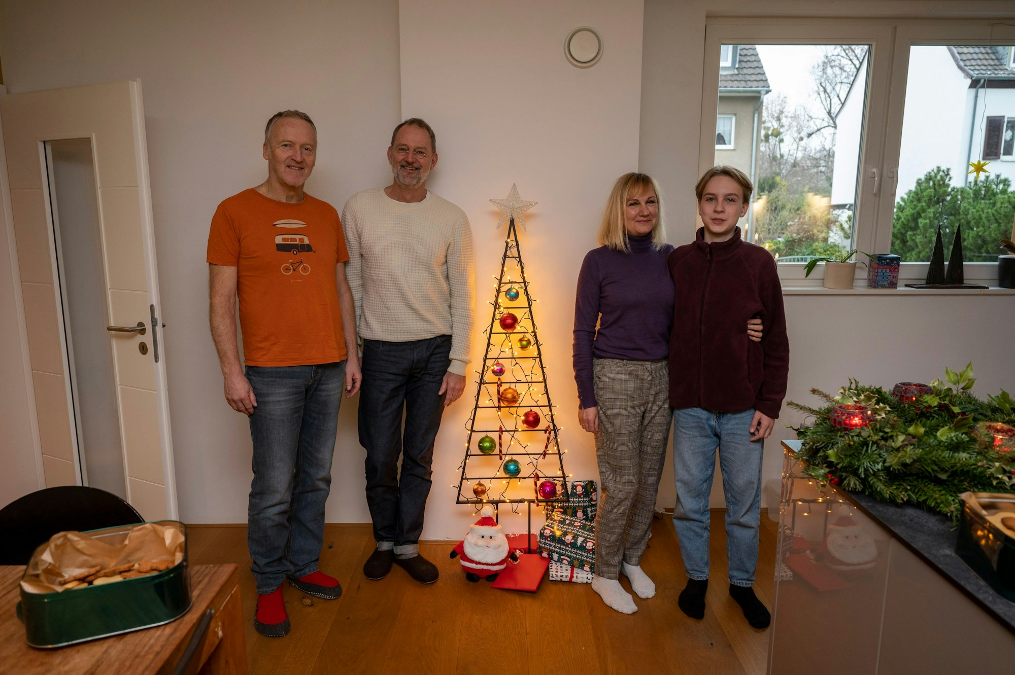 Svetlana Kiktieva steht Arm in Arm mit ihrem Sohn Oleksij vor einem Weihnachtsbaumgestell, links daneben stehen ihre Gastgeber Michael Znamenacek und Gert van der Kwartel