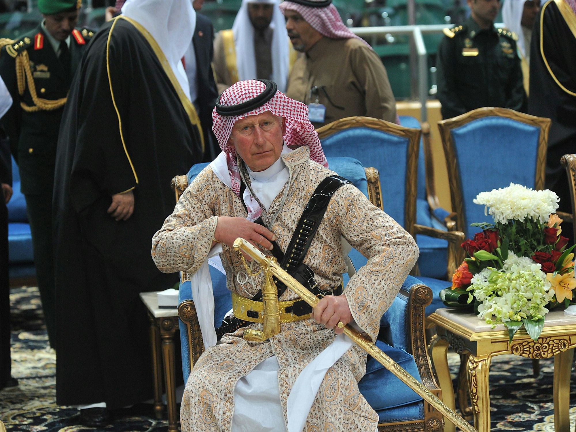 Prinz Charles trägt traditionelle saudische Kleidung und hält einen Säbel.